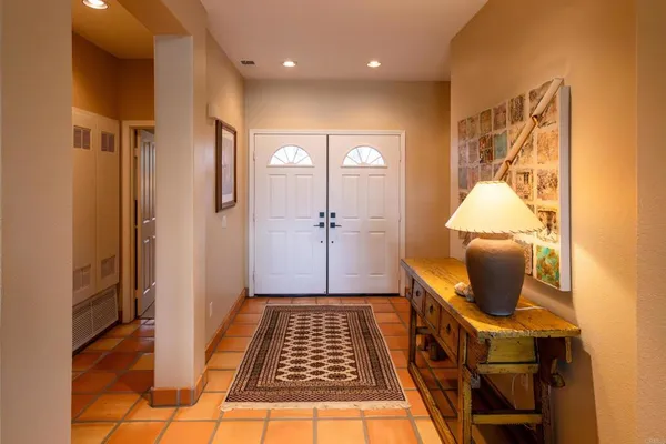 a view of a hallway with wooden floor and a bathroom