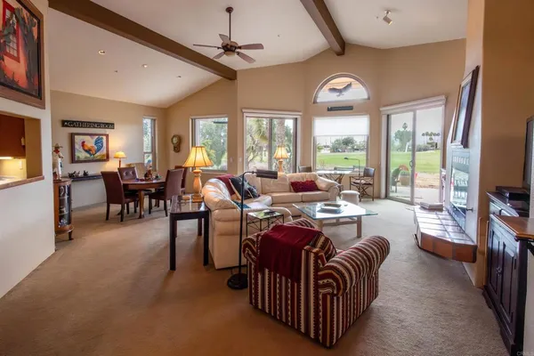 a living room with furniture a chandelier and a large window