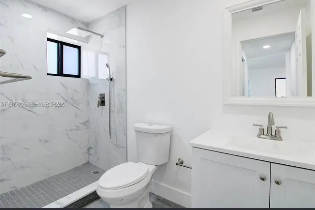 a white toilet sitting next to a bathroom sink