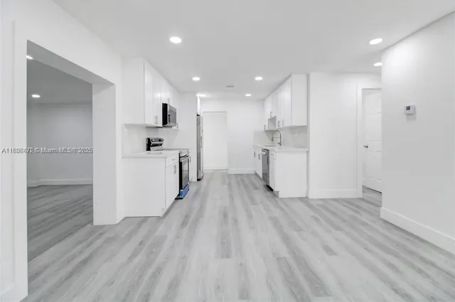 a view of a kitchen with wooden floor and a sink