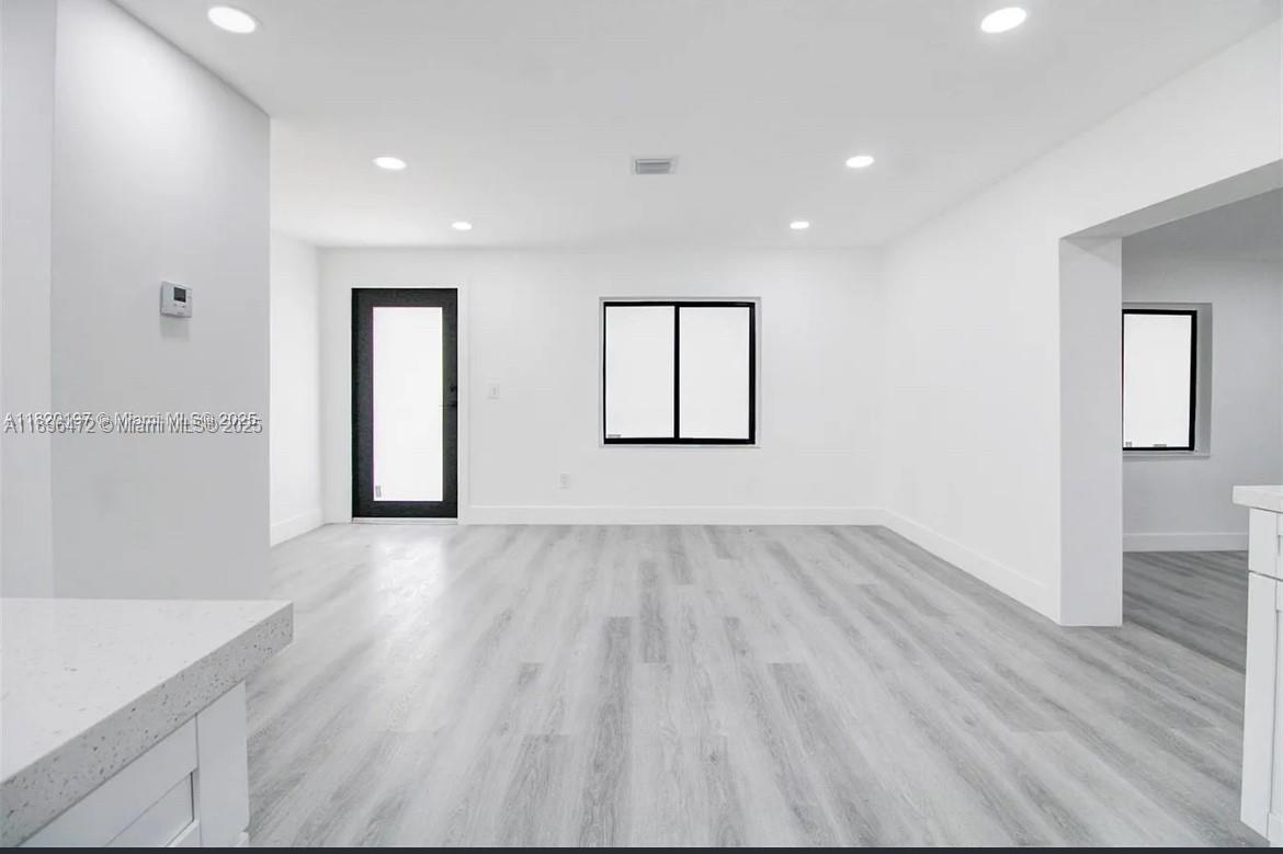 13885 Northwest 5th Avenue North Miami, FL 33168 - Photo 4 of 14 an empty room with wooden floor and windows
