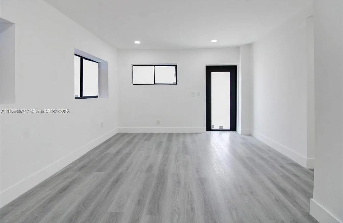13885 Northwest 5th Avenue North Miami, FL 33168 - Photo 5 of 14 an empty room with wooden floor and windows
