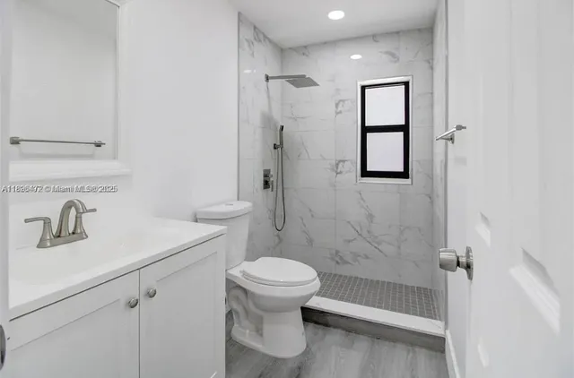 a bathroom with a sink a toilet and shower