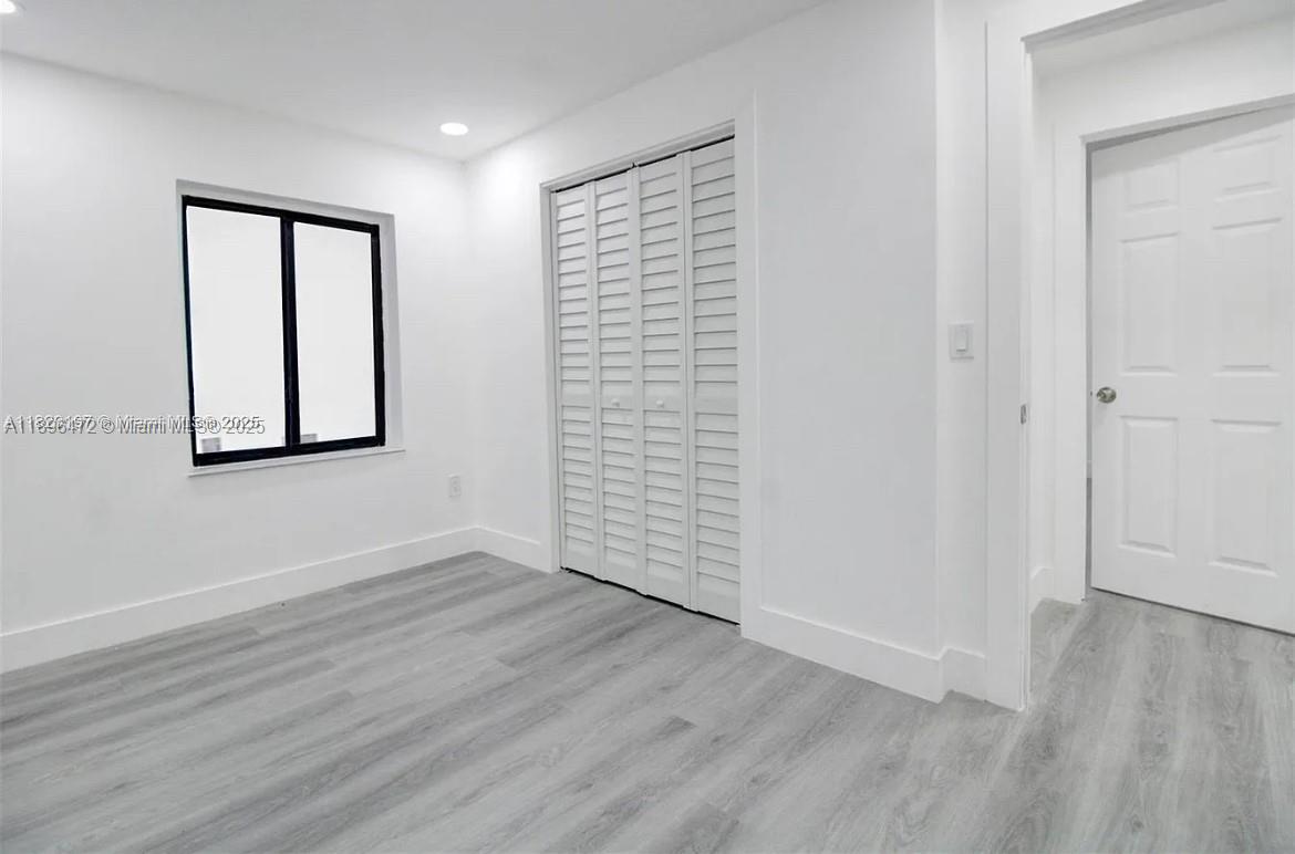 13885 Northwest 5th Avenue North Miami, FL 33168 - Photo 8 of 14 an empty room with wooden floor and windows