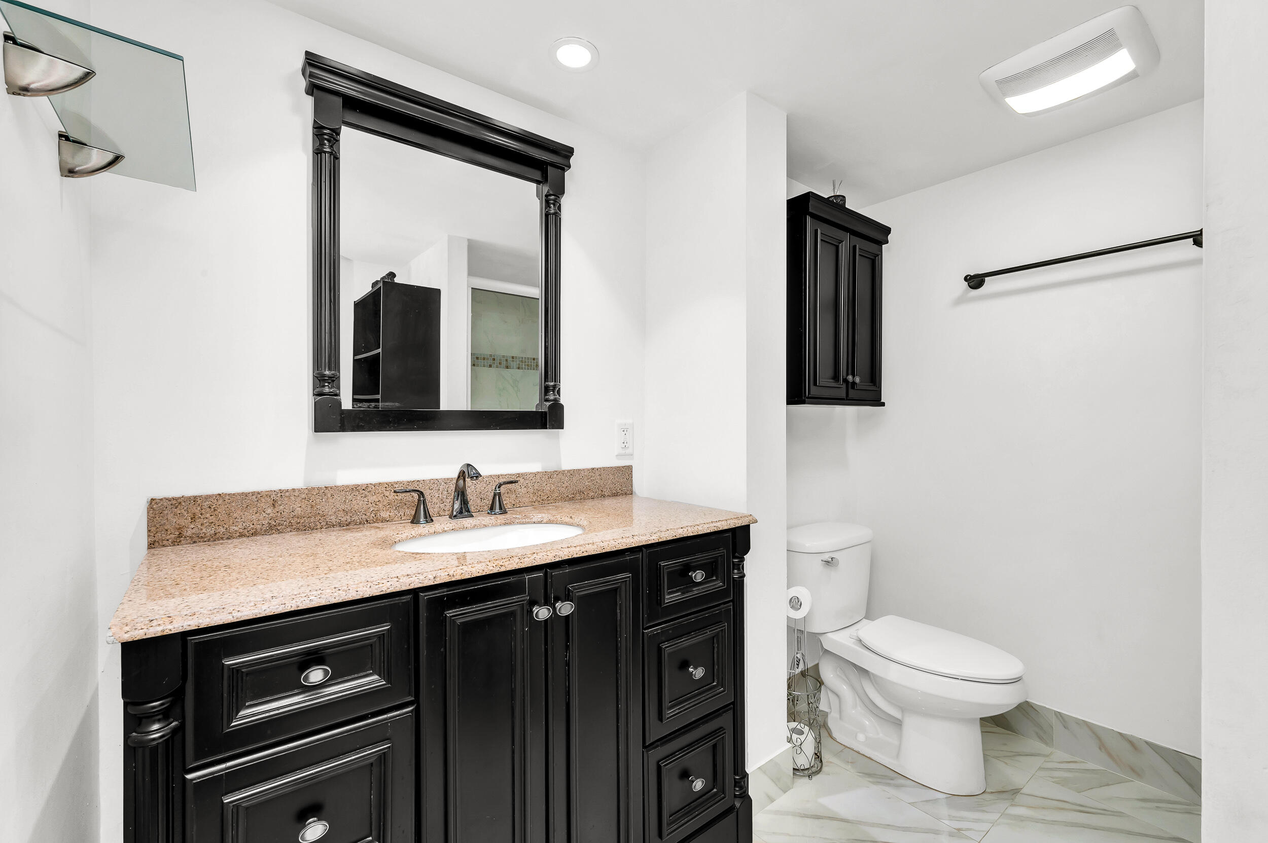 1111 South Ocean Boulevard, Unit 420 Boca Raton, FL 33432 - Photo 13 of 23 a bathroom with a toilet a sink a mirror and vanity