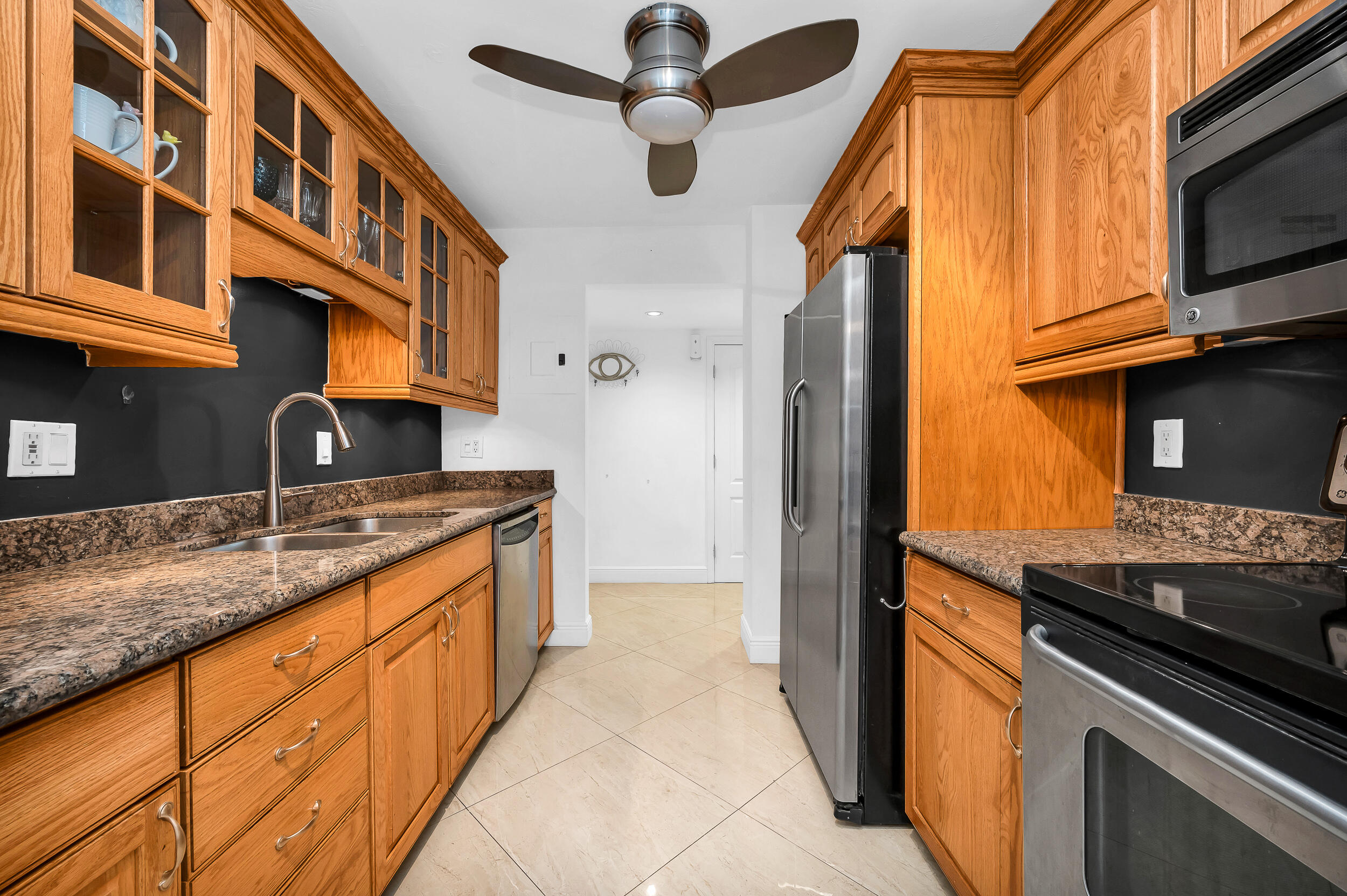 1111 South Ocean Boulevard, Unit 420 Boca Raton, FL 33432 - Photo 2 of 23 a kitchen with stainless steel appliances granite countertop a sink and a stove