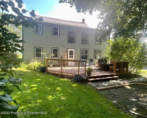 a kitchen with stainless steel appliances granite countertop a stove top oven a sink a dining table and chairs with wooden floor