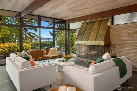 a living room with furniture a fireplace and a large window