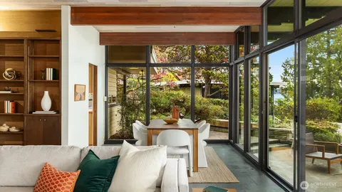 a dining room with glass top table and chairs