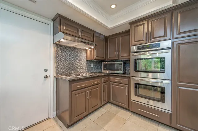 a kitchen with stainless steel appliances granite countertop a refrigerator and a stove top oven