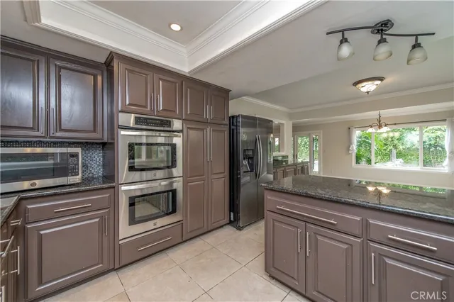 a kitchen with stainless steel appliances granite countertop a refrigerator and a sink