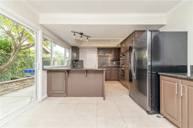 a kitchen with stainless steel appliances granite countertop a refrigerator and a sink