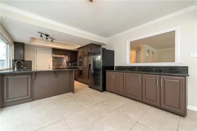 a kitchen with granite countertop a refrigerator and a sink