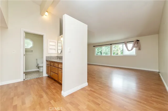 a view of a hallway with wooden floor and a living room