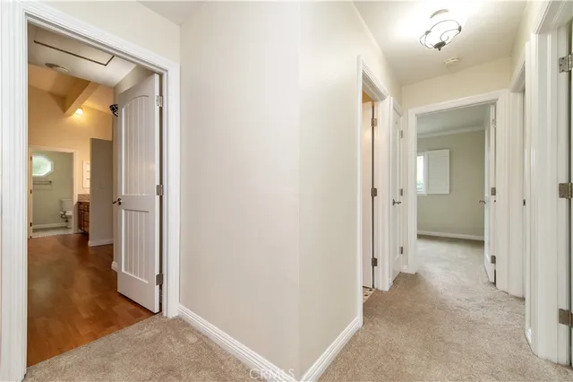 a view of a hallway with wooden floor and a living room
