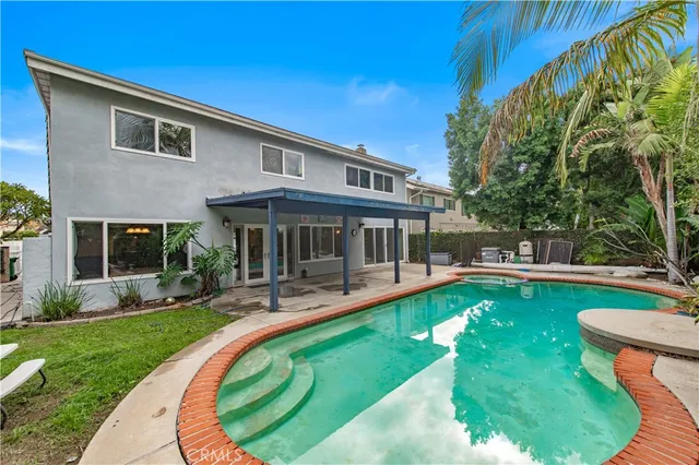 a view of a house with a yard patio and swimming pool
