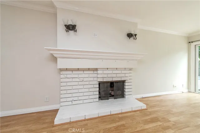 a view of empty room with wooden floor and fireplace