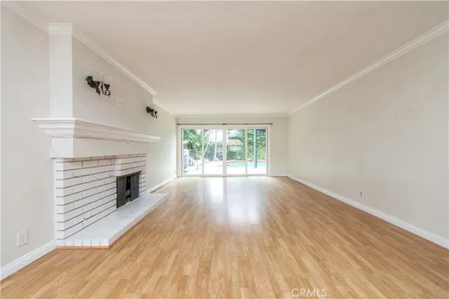 a view of empty room with wooden floor and fireplace