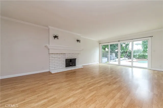 a view of empty room with wooden floor and fireplace