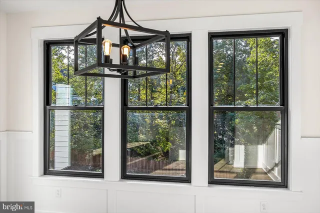a view of an empty room with wooden floor fireplace and a window