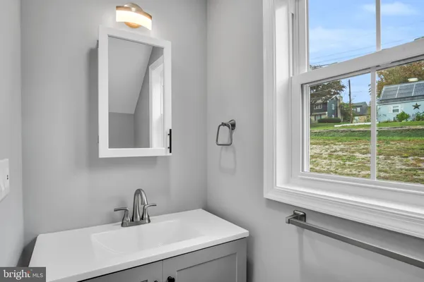 a bathroom with a sink mirror and a window