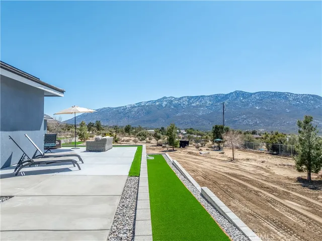 an outdoor sitting area with furniture and umbrella