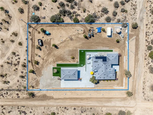 an aerial view of residential houses with outdoor space and trees