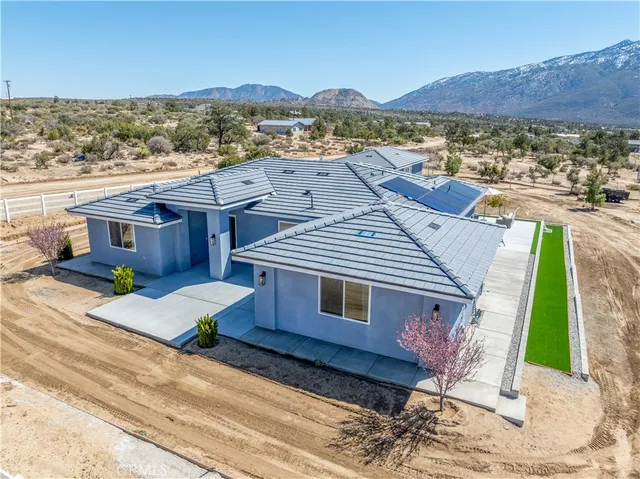 an aerial view of a house with a yard