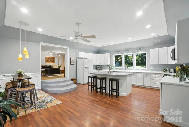 a kitchen with stainless steel appliances granite countertop a dining table chairs and granite counter tops