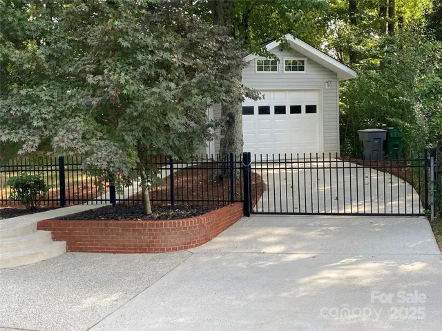 a view of a white house with iron fence