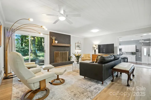 a living room with furniture a fireplace and a chandelier