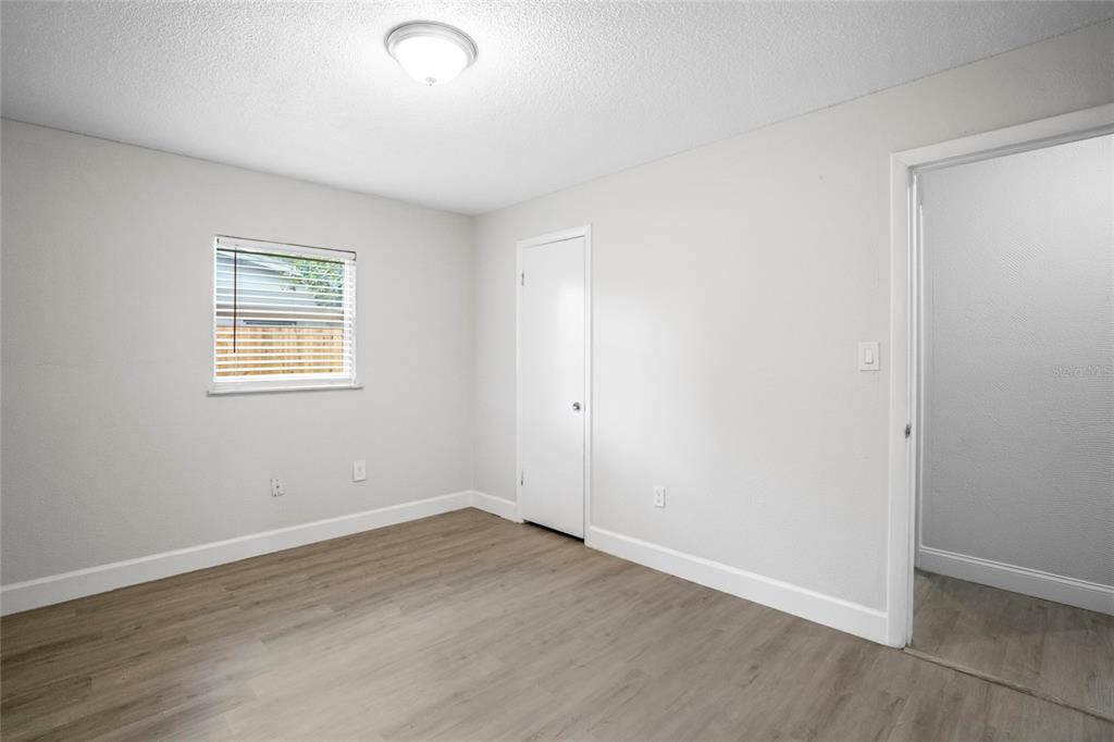 4138 Westgate Road Orlando, FL 32808 - Photo 17 of 29 an empty room with wooden floor and windows