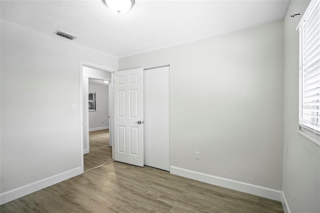 4138 Westgate Road Orlando, FL 32808 - Photo 21 of 29 an empty room with wooden floor and windows
