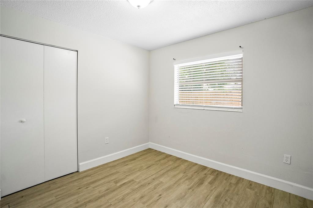 4138 Westgate Road Orlando, FL 32808 - Photo 22 of 29 a view of an empty room with wooden floor and a window