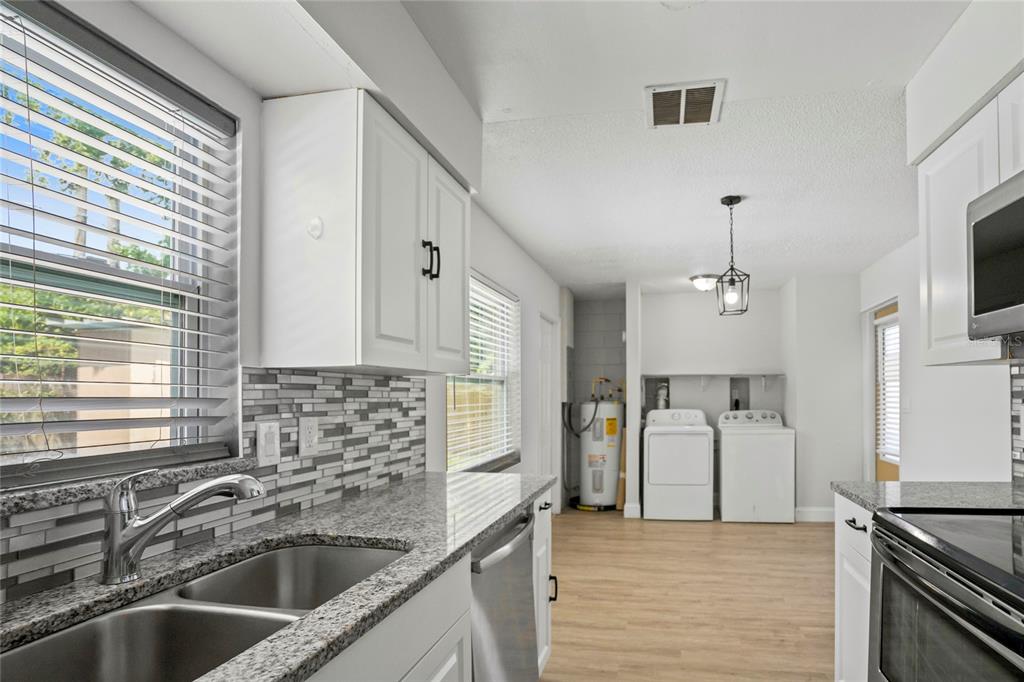 4138 Westgate Road Orlando, FL 32808 - Photo 5 of 29 a kitchen that has a sink cabinets counter space and stainless steel appliances