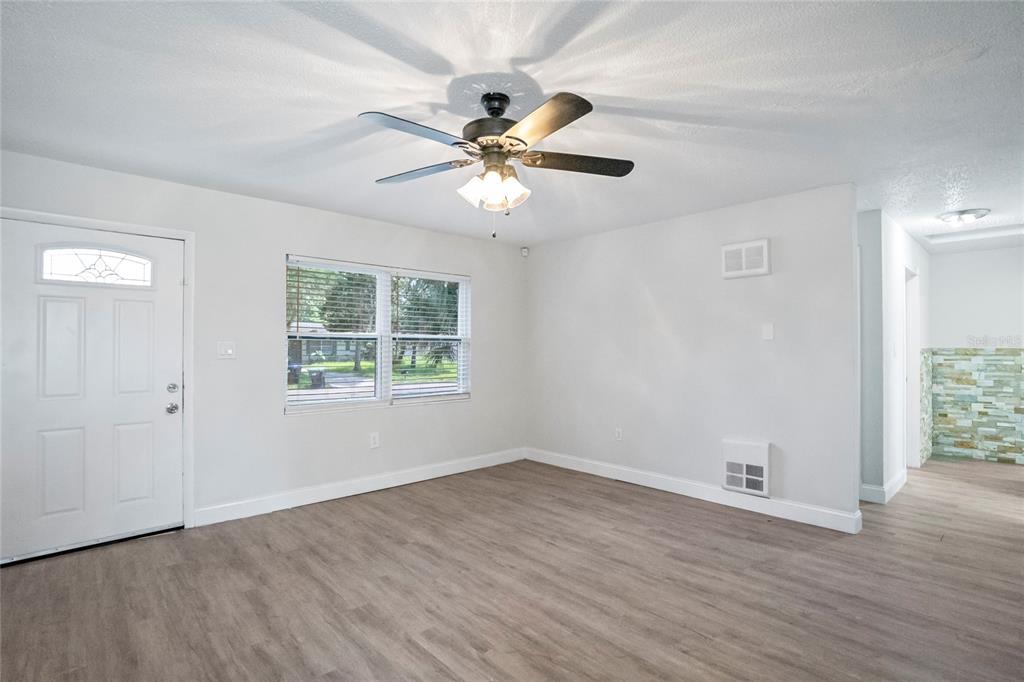 4138 Westgate Road Orlando, FL 32808 - Photo 10 of 29 a view of a room with wooden floor and a ceiling fan