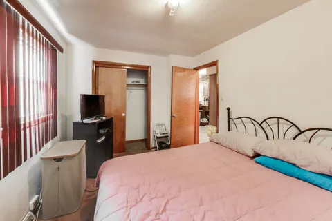 a bedroom with a bed a large mirror and flat screen tv