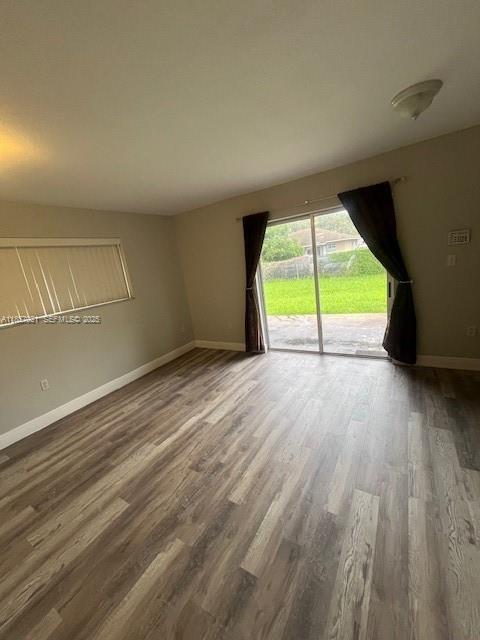3985 Northwest 165th Street Miami Gardens, FL 33054 - Photo 2 of 9 a view of an empty room with wooden floor and a window
