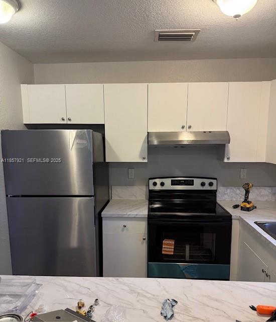 3985 Northwest 165th Street Miami Gardens, FL 33054 - Photo 3 of 9 a kitchen with a refrigerator stove and white cabinets