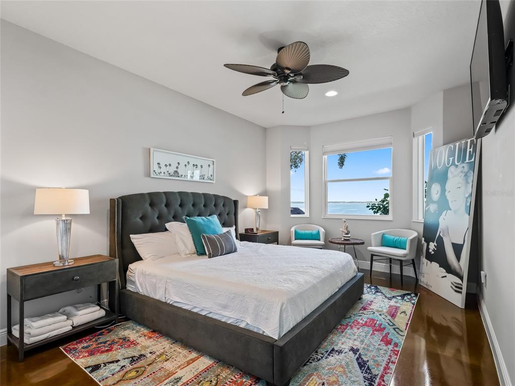 12943 Southeast Sunset Harbor Road Weirsdale, FL 32195 - Photo 58 of 87 a bedroom with a bed a couch and a chandelier