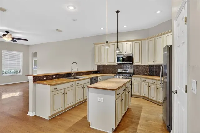 a kitchen with stainless steel appliances granite countertop a sink a stove and a refrigerator