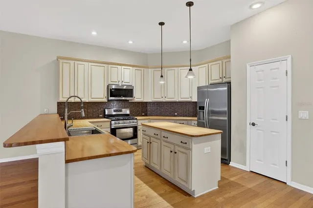 a kitchen with a stove a refrigerator a oven and a sink with wooden floor