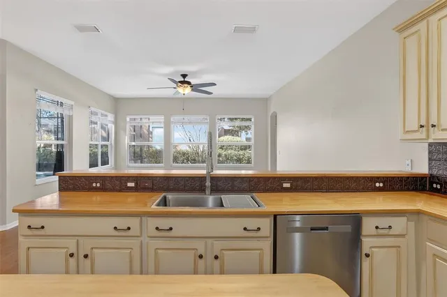 a view of a kitchen with a sink and dishwasher with wooden floor
