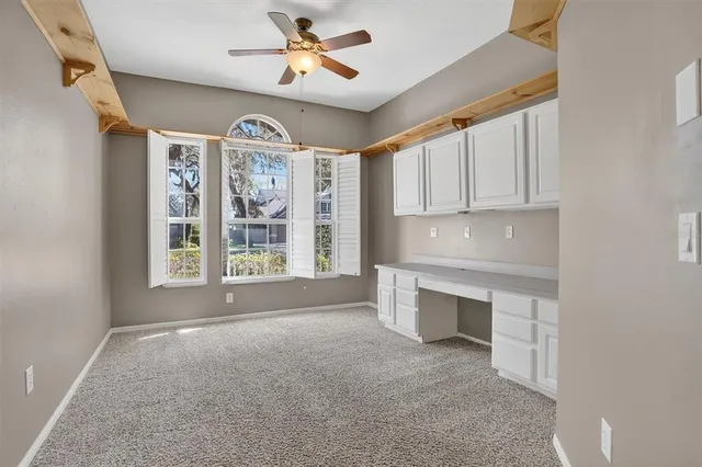 a view of an empty room with cabinet and a window