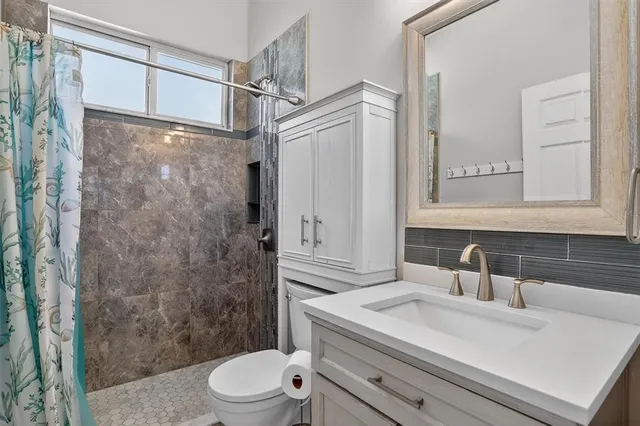 a bathroom with a sink a toilet and shower