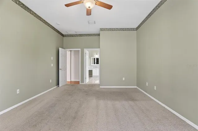 en empty room with windows and ceiling fan