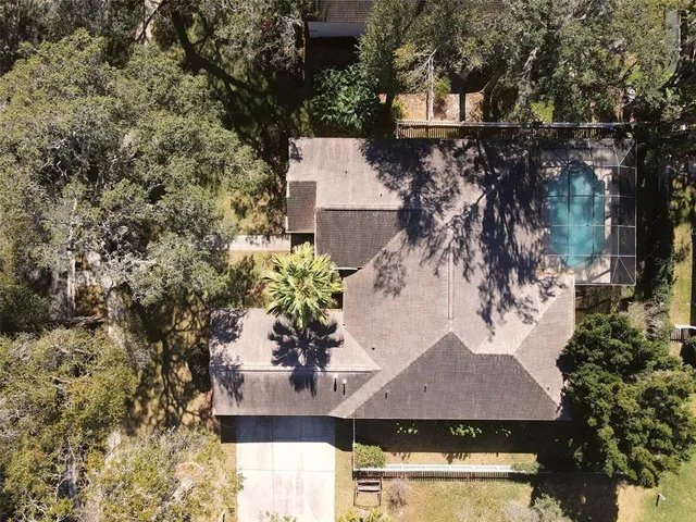 an aerial view of a house with yard and seating space