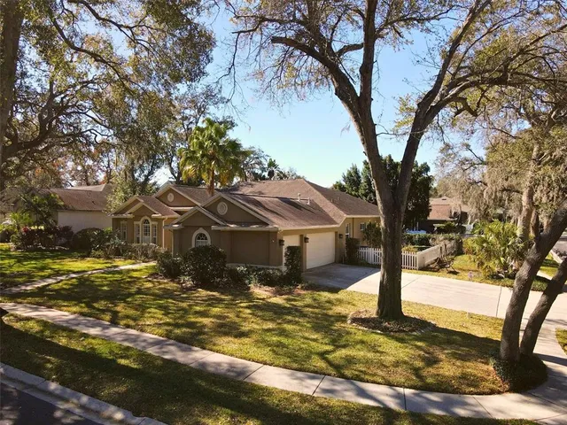 a front view of a house with a yard covered with trees