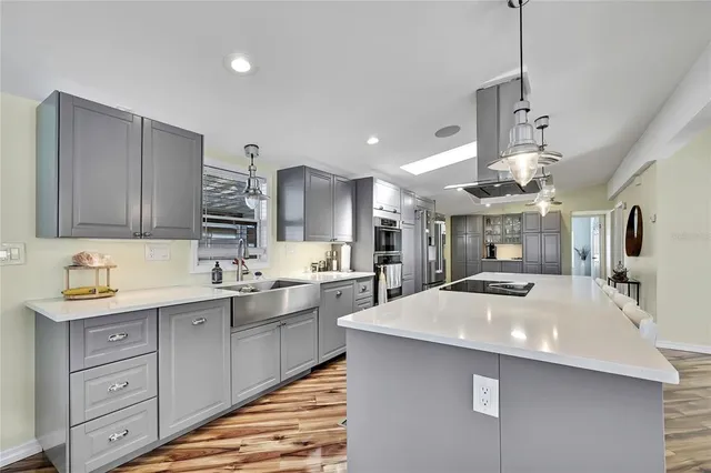 a large kitchen with sink a counter space and cabinets