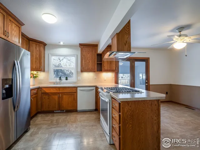 a kitchen with granite countertop a sink stove and refrigerator